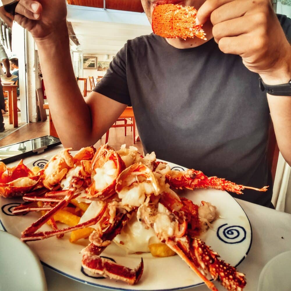 Homard frit avec pommes de terre frites et œufs au plat dans le port de Mahó