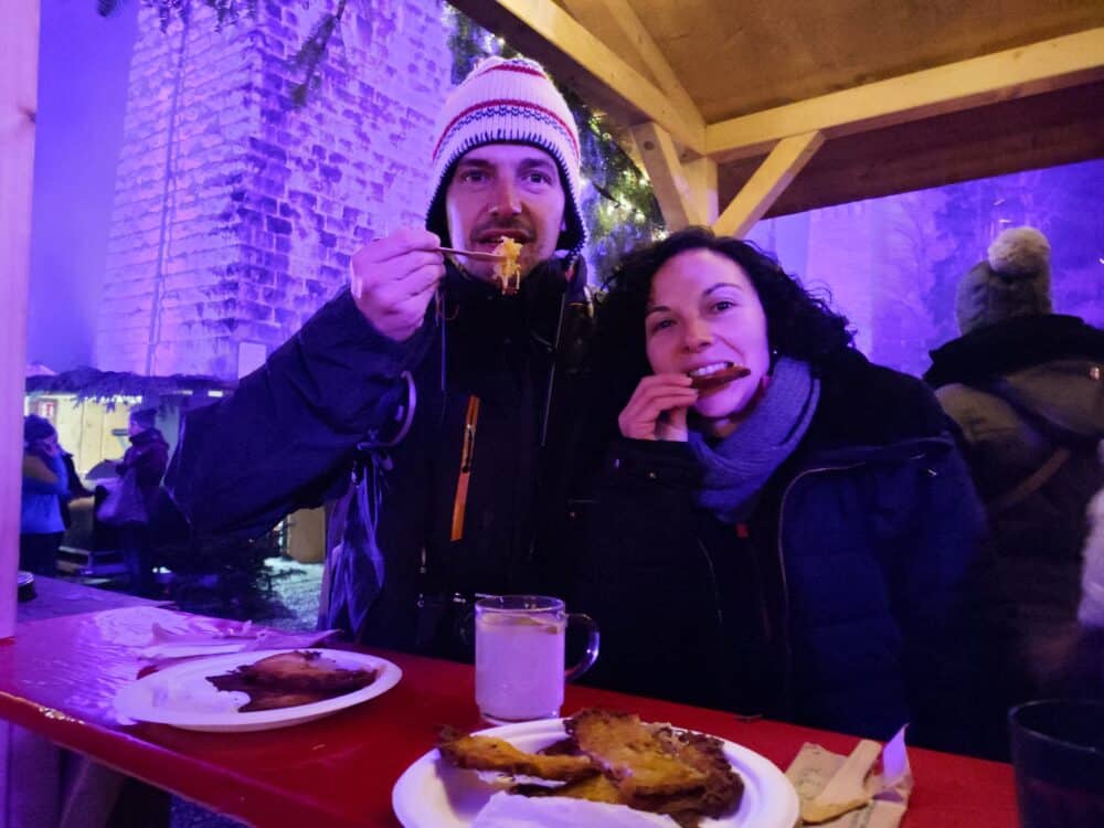 Comendo Kartoffenpujjer, o tipo de omelete de batata, mas sem ovo no mercado de Natal de Ravenna na Floresta Negra Alemanha no Natal