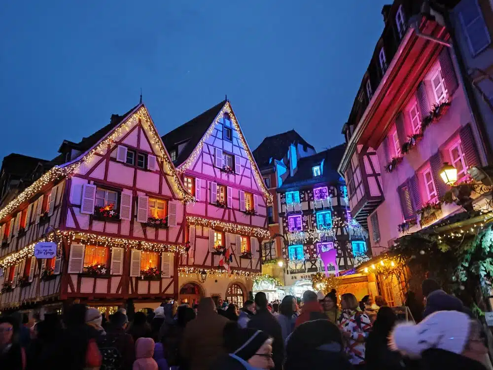 Colmar a Natale con le sue case a graticcio illuminate e affollate di gente