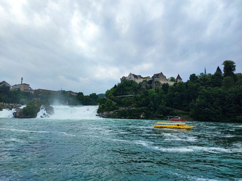 As Cataratas do Reno com o barco que atravessa para o outro lado para subir aos miradouros à direita e ao Castelo